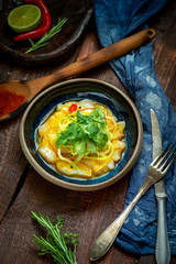 Halibut fillet ceviche with marinated, green, parsley, onion on blue plate. Fresh fish tartare, top view