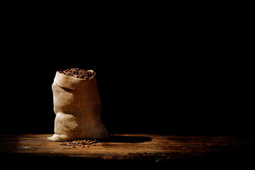 Fresh coffee grains in brown sack and free space for your decoration. 