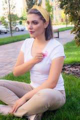 Obraz premium The girl holding a pink ribbon, symbol of cancer. Breast cancer awareness month.Strong woman fights cancer.