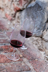 Bicchieri di vino su un vecchio muro di pietra in Toscana, Italia