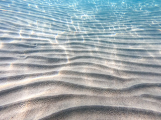 Clear water. underwater background with sandy sea bottom. Beautiful texture of the sea and ocean water.