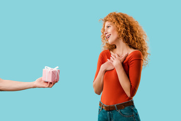 beautiful redhead woman with gift box isolated on blue