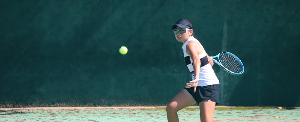 フォアハンドを打つ女子テニスプレイヤー