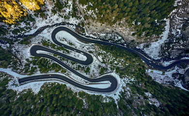 Aerial drone view of a serpentine in rocky mountain forest, Bicaz gorge with winding road in winter season,Cheile Bicazului, Romania