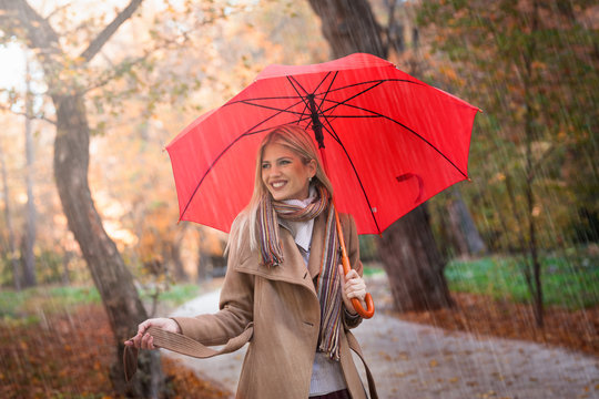 Happy young woman enjoy in autumn rain