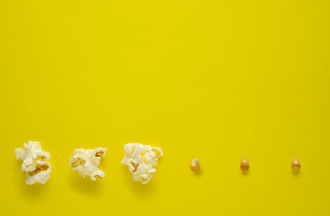 Creative concept food photo of popcorn seeds on yellow background.