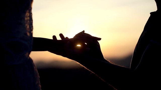 Slow motion close up of in love guy putting engagement ring to his loved girlfriend at sunset for Valentines day. Getting engaged. Man proposes marriage.