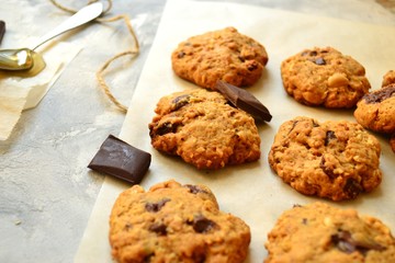 Oatmeal cookies with chocolate. Cookies on a light background with parchment.