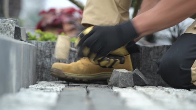 Construction Worker and Path Brick Paving Job Closeup