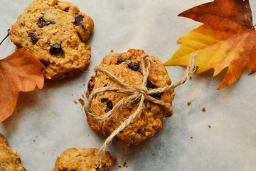 Oat cookies. Cookies on a light background with parchment. Sweet pastries with an autumn theme and autumn yellow leaves. Autumn appetizing background.