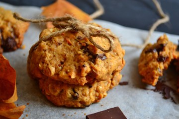 Oat cookies. Cookies on a light background with parchment. Sweet pastries with an autumn theme and autumn yellow leaves. Autumn appetizing background.
