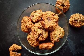 Oatmeal cookies with chocolate. Cookies on a black table background, isolated. A stack of cookies with cords.