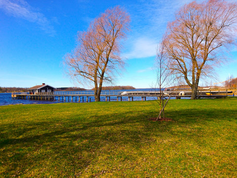Tranquil Lakeside Pier with Boathouse on a Clear Spring Day