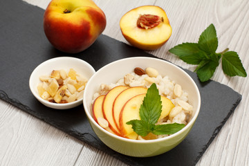 Sorghum salad with nuts and fresh peach on stone board.