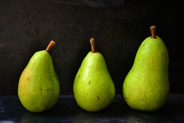 Fototapeta na wymiar Pear on a dark background. ripe pears of green color. Fruit in a low key. Beautiful green color