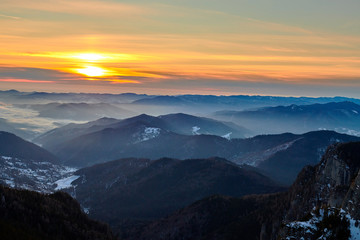 Naklejka na ściany i meble Aerial Landscape view from Ceahlău Mountains National Park at sunset in winter season,Sunset in Ceahlau Mountains