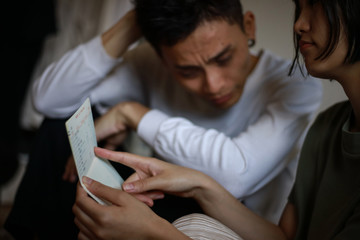 通帳を見ながら悩む夫婦