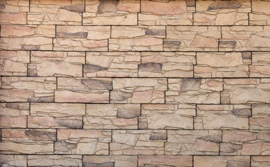 Textured beige wall made of artificial stone. Trendy modern abstract background.