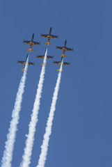 Blue and yellow reactive planes flying in the sky and performing a show
