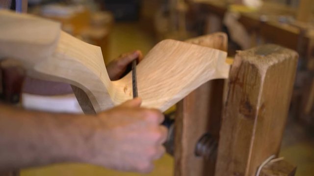 Old craftsman making a historic forcola, a wooden oarlock for gondolas, the traditional boats in Venice, Venezia. 
