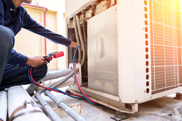 Technician is checking air conditioner ,measuring equipment for filling air conditioners.