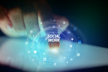 Finger touching tablet with social media icons and SOCIAL WORK