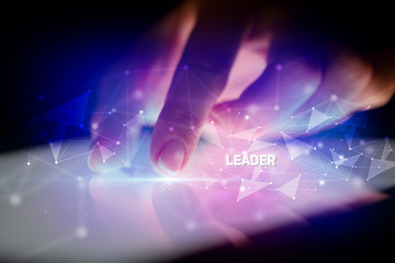 Finger touching tablet with LEADER inscription, business concept