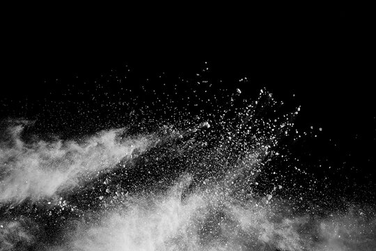 White powder explosion isolated on black background. White dust particles splash.