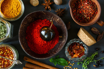 Variety colorful hot spices on dark background. - 289086912