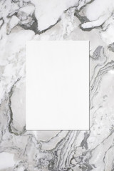 Empty white vertical rectangle poster or business card mockup with soft shadow on grey marble background. Flat lay, top view
