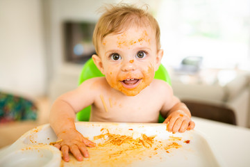 A Little baby eating her dinner and making a mess