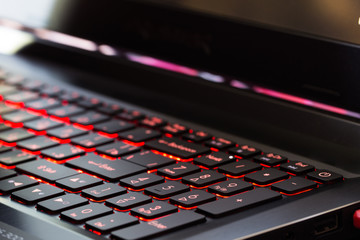 Fototapeta na wymiar Red backlit laptop keyboard. Close-up.