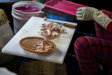 woman is cutting the octopus at the seafood market