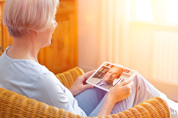 Senior people e-learning concept, old woman with tablet pc at home during an online lesson with her...