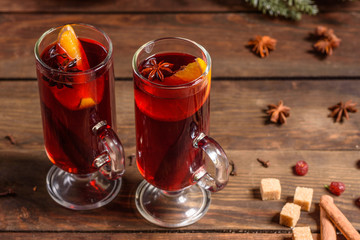 Christmas hot mulled wine with cinnamon cardamom and anise on wooden background