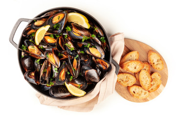 Marinara mussels, moules mariniere, shot from the top in a cooking pan with toasted bread on a white background with a place for text