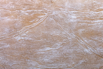 Modern wall with decorative beautiful textured beige stucco with spots, cracks and scratches. Trendy modern texture abstract background.