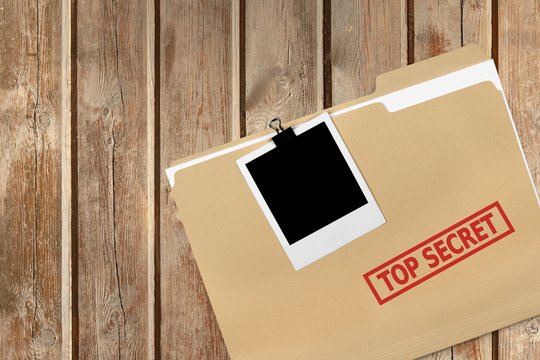 A manila folder with the faded words Top Secret on the front, isolated on background