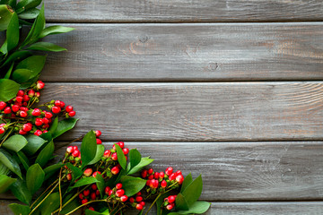 Summer pattern with green plants and red berries on wooden background top view mockup