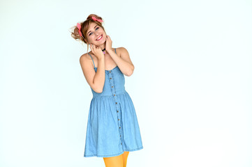 Portrait of a cute happy funny blonde girl with colored hair in a funny dress on a white background. Smiling in various poses, beauty, holiday.