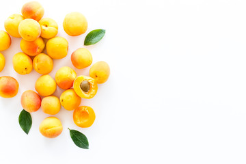 Fruit background with apricots and leaves on white background top view space for text