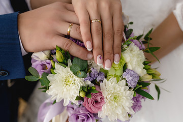 Obraz na płótnie Canvas Hands of groom and bride, wedding bouquet