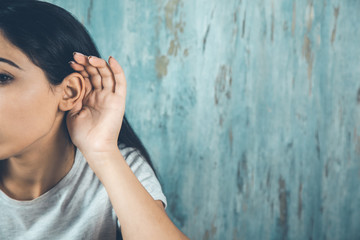 surprised woman hand in ear on abstract background