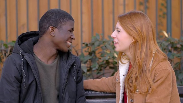 Young Woman refusing black man  trying to kiss her in the park