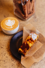 Coffee, cappuccino and cake on light texture background