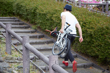 折り畳み自転車を持ち運ぶ男性