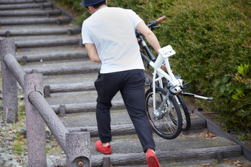 折り畳み自転車を持ち運ぶ男性