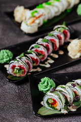 Various kinds of sushi served on black stone