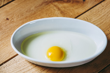 Jaune d'oeuf dans un plat blanc pour cuisiner