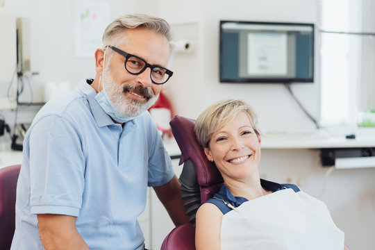 Smiling dentist with a happy woman patient